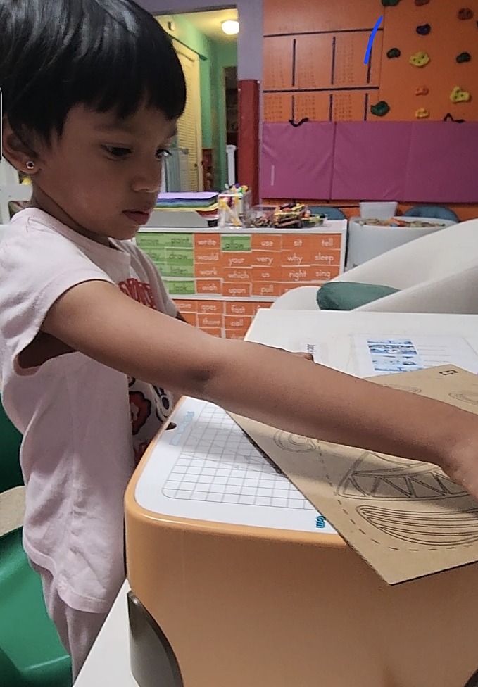 Child working at the classroom word wall